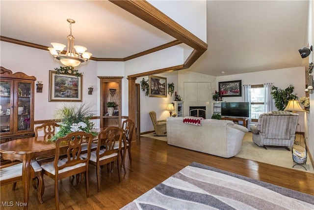 dining room with crown molding, lofted ceiling, a notable chandelier, and dark hardwood / wood-style flooring