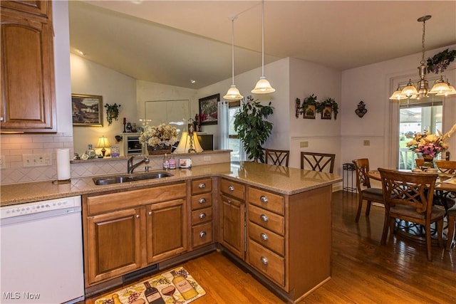 kitchen featuring pendant lighting, dishwasher, sink, and kitchen peninsula