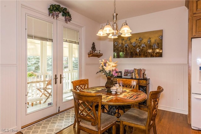 dining area featuring a notable chandelier, dark wood-type flooring, and french doors