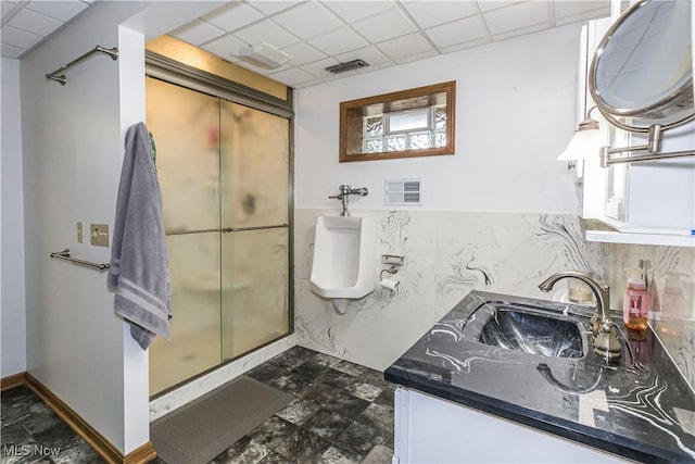 bathroom with tasteful backsplash, vanity, a paneled ceiling, and a shower with shower door