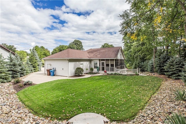 rear view of house featuring a patio area, a sunroom, and a lawn