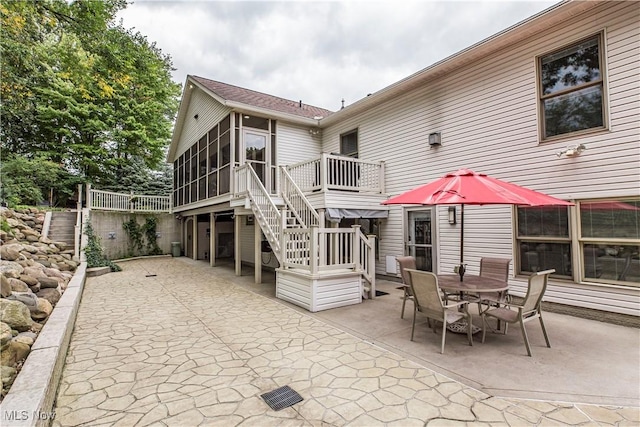 rear view of house featuring a sunroom and a patio