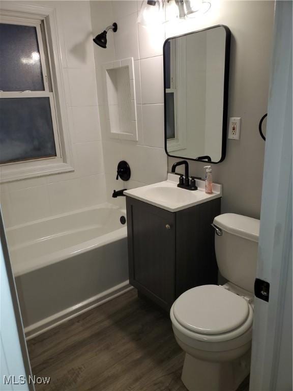 full bathroom with wood-type flooring, vanity, shower / bathtub combination, and toilet