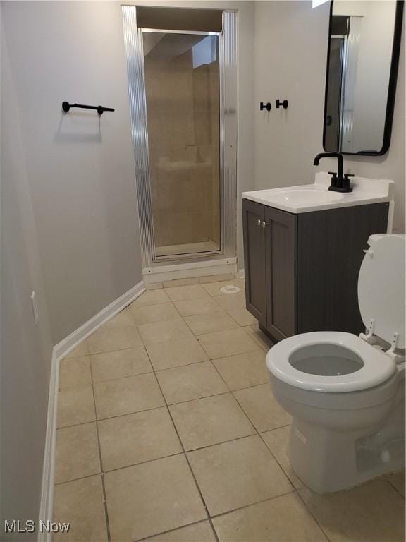 full bath with tile patterned flooring, baseboards, toilet, a stall shower, and vanity