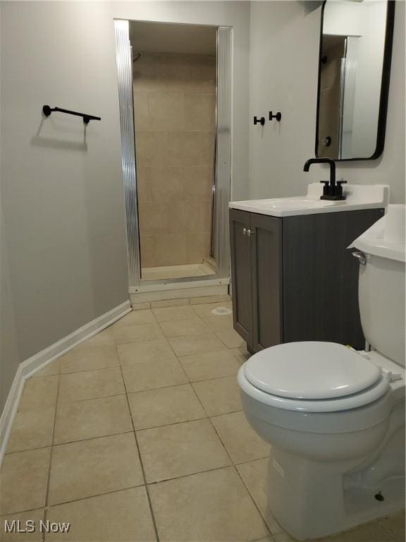 bathroom with tile patterned floors, baseboards, toilet, and a stall shower