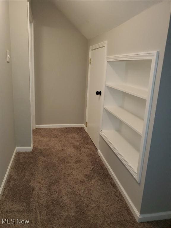 interior space featuring carpet flooring, baseboards, and vaulted ceiling