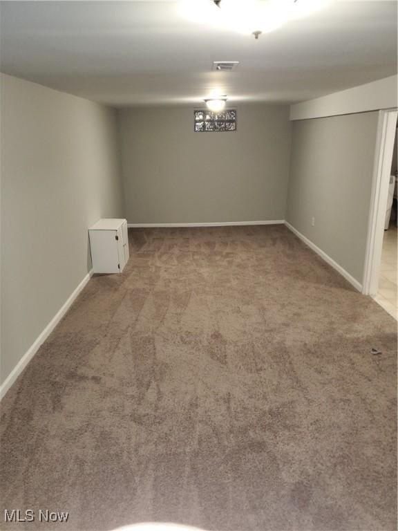 finished below grade area with carpet, visible vents, and baseboards