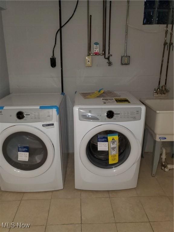 clothes washing area featuring light tile patterned floors