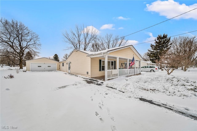 view of snow covered exterior with an outbuilding, a garage, and covered porch