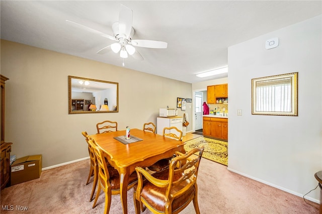 carpeted dining area featuring ceiling fan