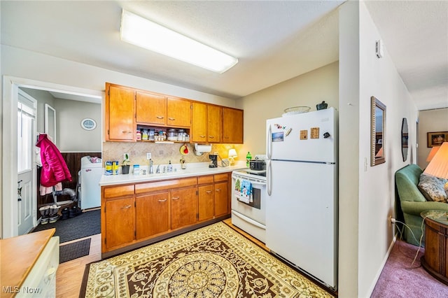 kitchen with tasteful backsplash, washer / clothes dryer, white appliances, and sink