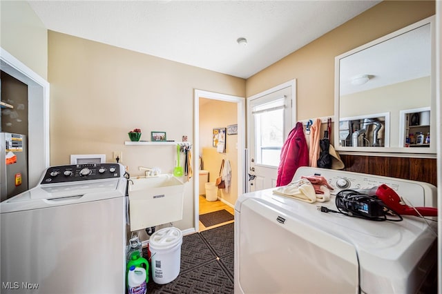 clothes washing area featuring sink and washing machine and clothes dryer