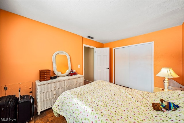 bedroom featuring dark parquet floors and a closet