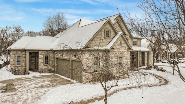 snow covered property with a garage