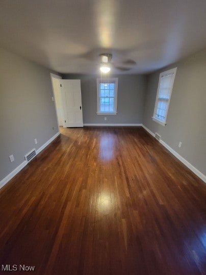 empty room featuring dark wood-type flooring and ceiling fan