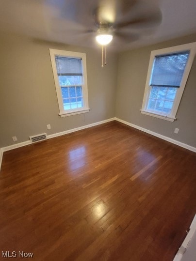 spare room featuring dark wood-type flooring and ceiling fan