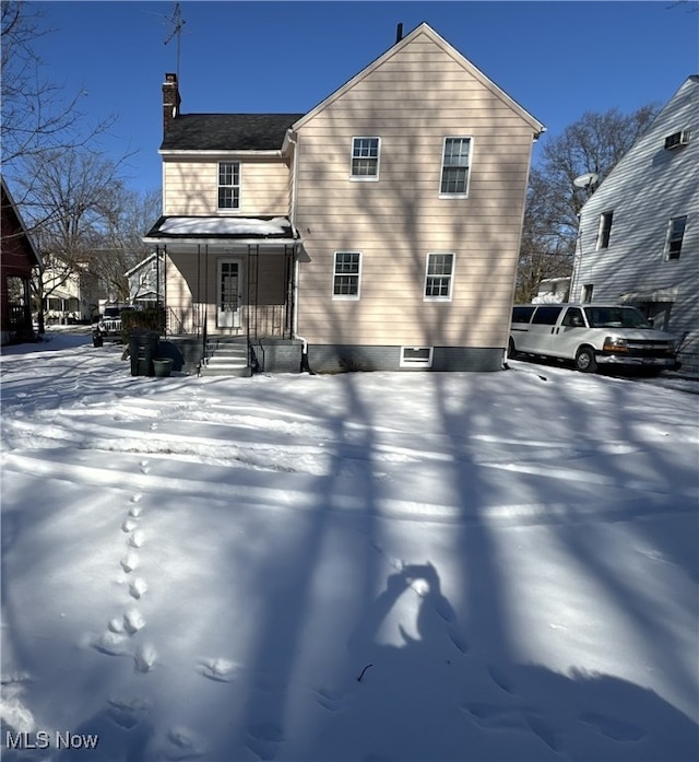 snow covered property featuring covered porch