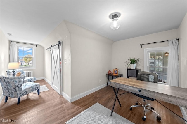 home office with hardwood / wood-style floors, radiator heating unit, and a barn door