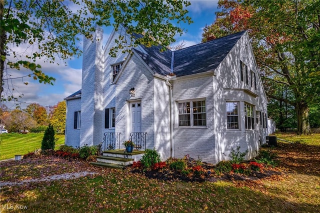 view of front of property featuring a front yard and cooling unit