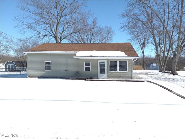 view of snow covered back of property