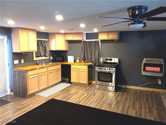 kitchen with light brown cabinets, butcher block counters, heating unit, and black appliances