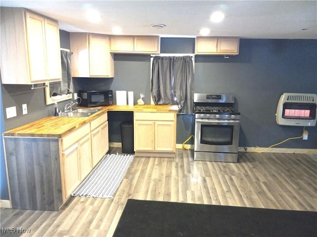 kitchen featuring wood counters, sink, heating unit, stainless steel gas stove, and light brown cabinets