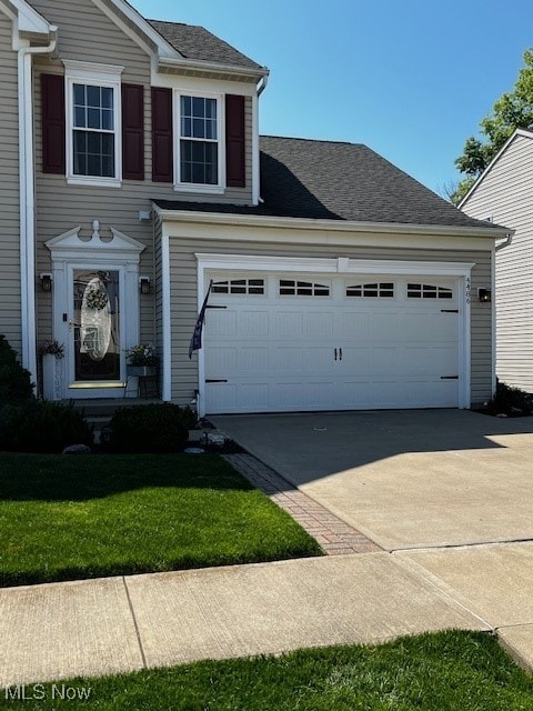 view of front of property featuring a garage and a front lawn