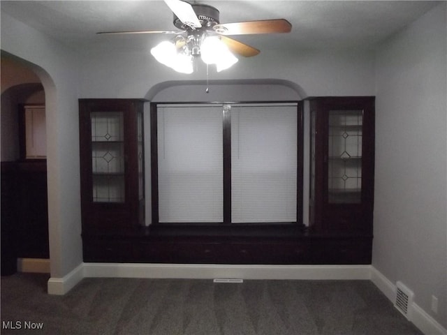 carpeted spare room featuring ceiling fan