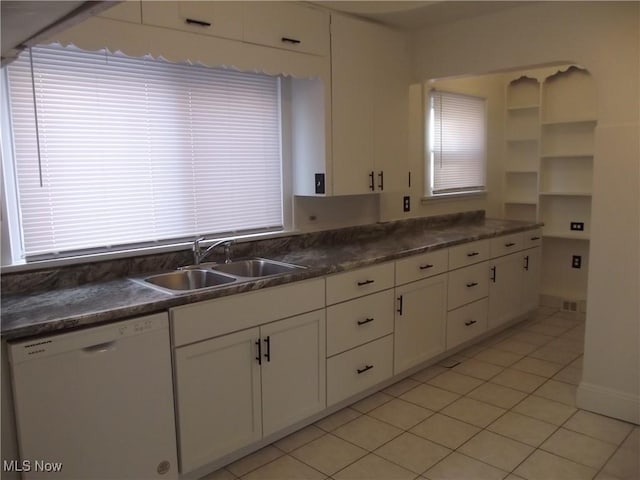 kitchen with dishwasher, sink, light tile patterned floors, and white cabinets