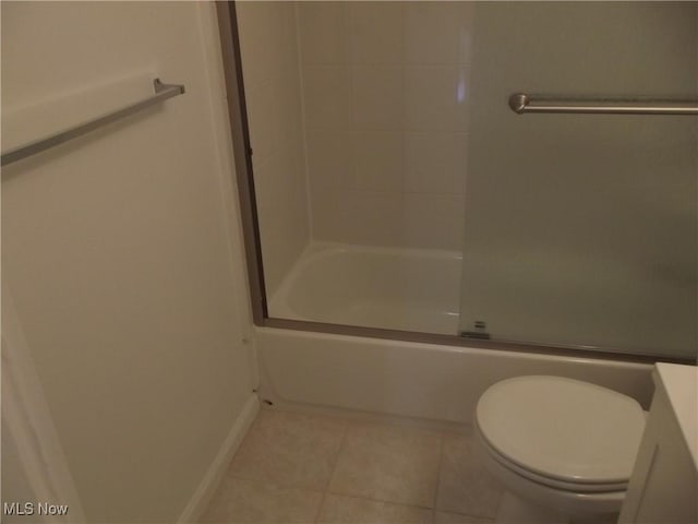 bathroom with combined bath / shower with glass door, tile patterned floors, and toilet