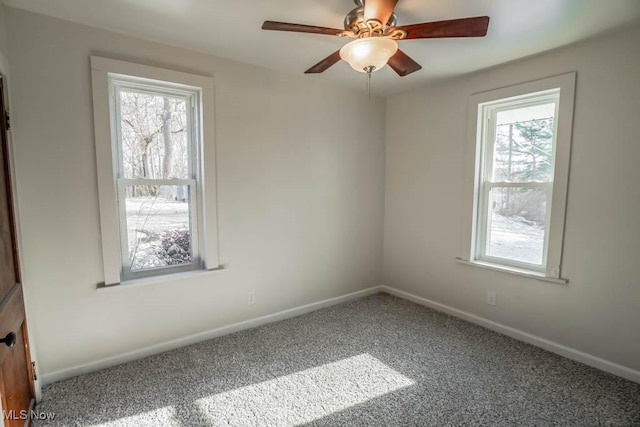 carpeted spare room with a wealth of natural light and ceiling fan