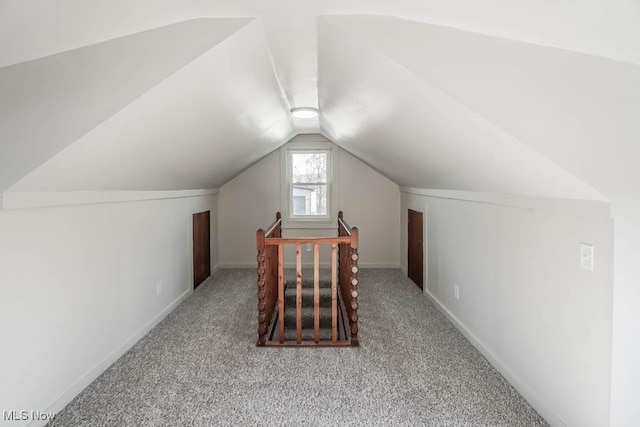 bonus room with light colored carpet and vaulted ceiling