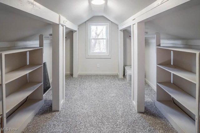 walk in closet featuring lofted ceiling and carpet flooring