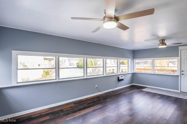 spare room featuring dark wood-type flooring and ceiling fan