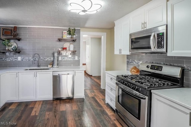 kitchen with sink, a textured ceiling, dark hardwood / wood-style flooring, stainless steel appliances, and white cabinets