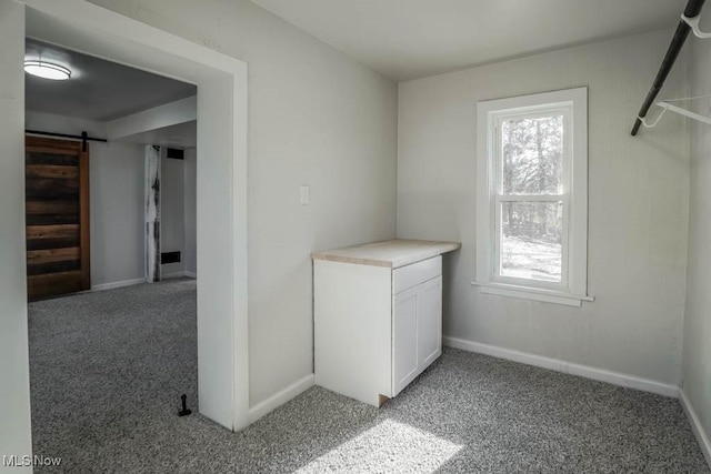 interior space featuring light colored carpet and a barn door