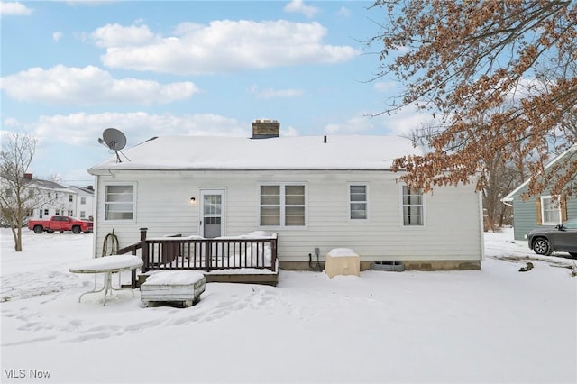 snow covered house featuring a deck