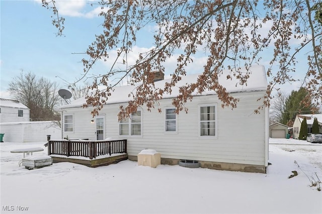 snow covered house with a wooden deck