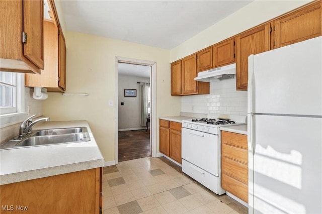 kitchen featuring tasteful backsplash, sink, and white appliances