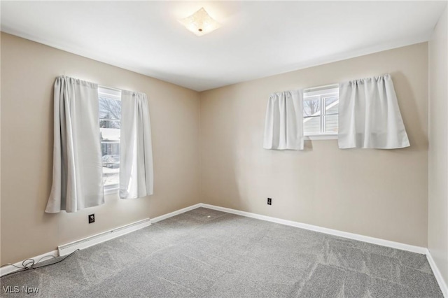 empty room featuring a baseboard radiator, carpet floors, and a healthy amount of sunlight