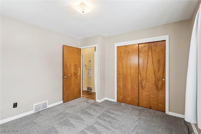 unfurnished bedroom with light carpet and a closet