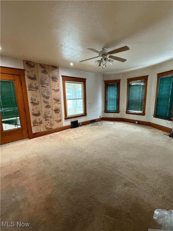 unfurnished room featuring ceiling fan, carpet, and a textured ceiling