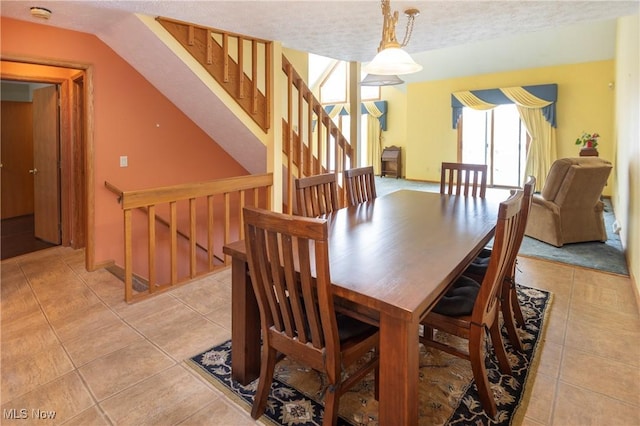 dining space with light tile patterned floors and a textured ceiling