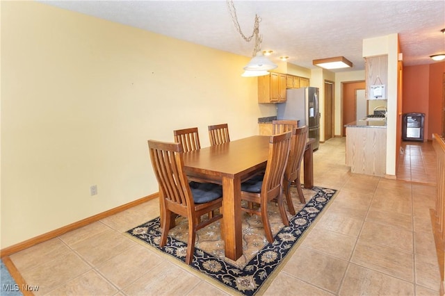 dining space with a textured ceiling and light tile patterned flooring