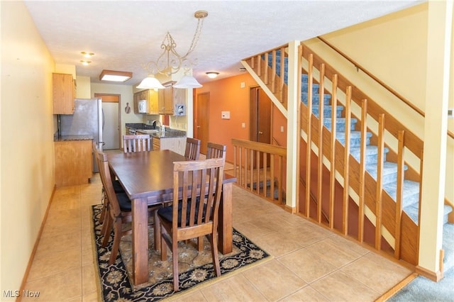 dining space with light tile patterned floors and a textured ceiling