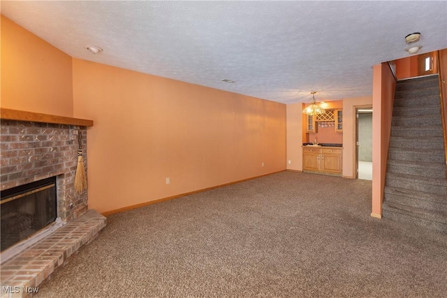 unfurnished living room featuring carpet floors, a fireplace, and a textured ceiling