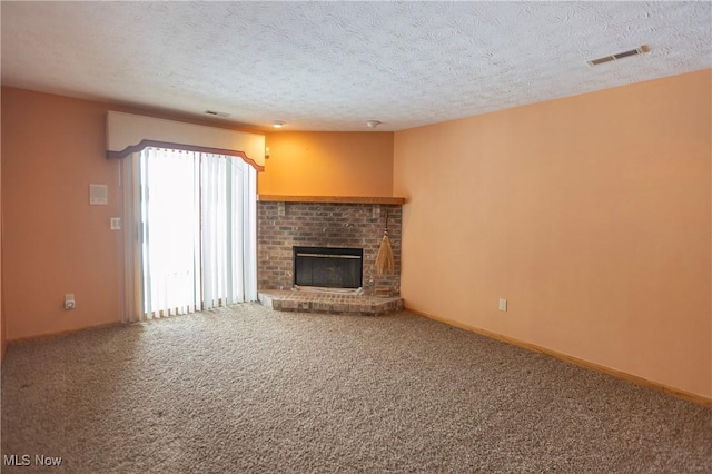 unfurnished living room featuring a fireplace, a textured ceiling, and carpet