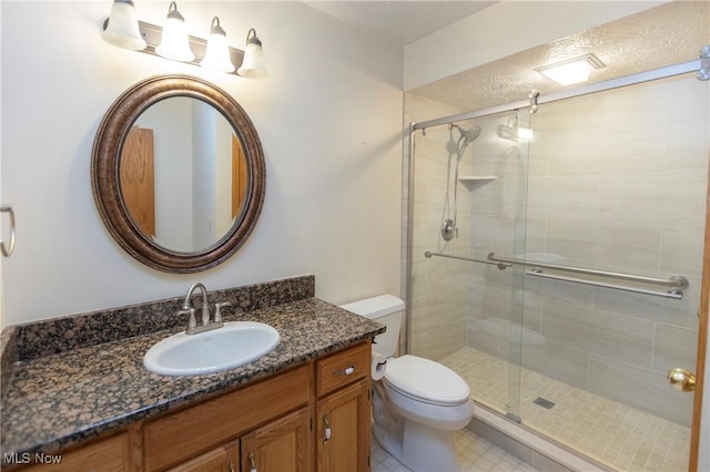 bathroom with vanity, toilet, and a shower with shower door