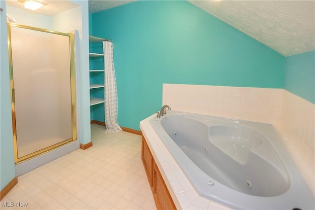 bathroom featuring a textured ceiling and separate shower and tub