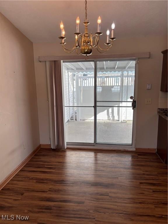 unfurnished dining area with an inviting chandelier, dark hardwood / wood-style flooring, and a wealth of natural light